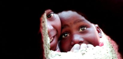 Children looking through a hole in the wall
