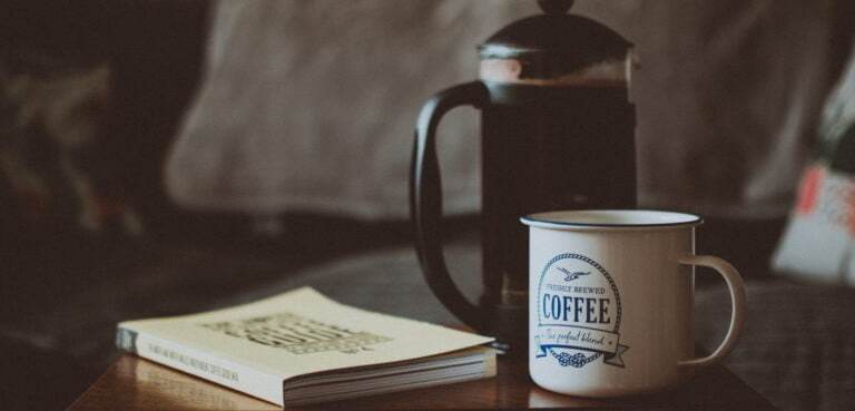 French press, coffee cup, and a book